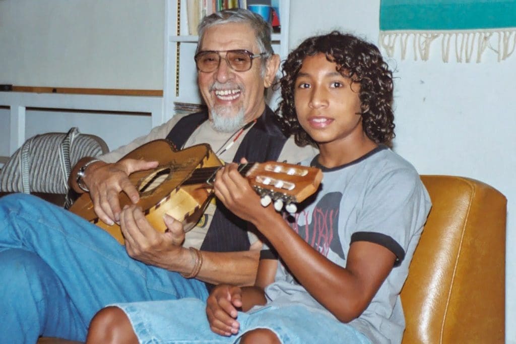 A man and a boy holding guitar in their hands