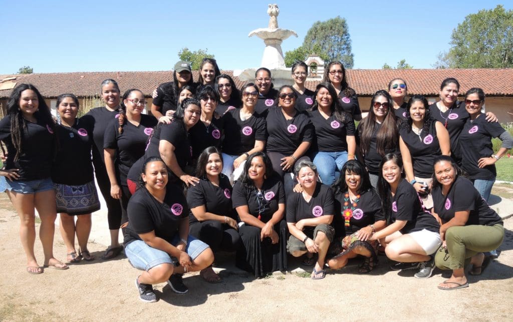 Group of women in black t shirts posing for a group photo